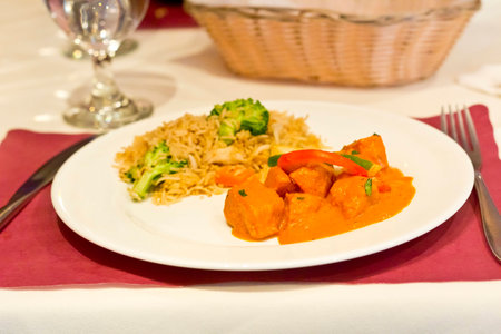 Authentic Indian chicken Tikka Masala garnished with bell peppers and a side of khao padの写真素材