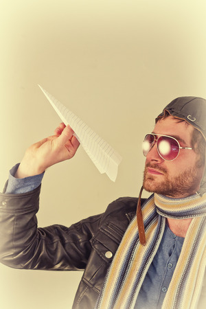 Aviator pilot with hat and sunglasses plays with paper planesの写真素材