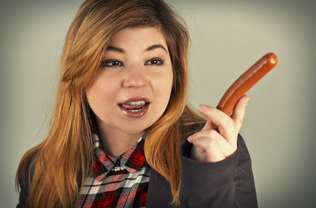 Cute hungarian girl points a hotdog as if to make an important pointの写真素材