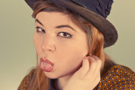 Tramp girl wears old top hat in vintage photo styleの写真素材