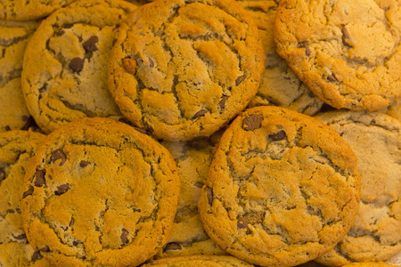 Bakery fresh chocolate chip cookies stacked in a display for sweet tooth backgroundの写真素材