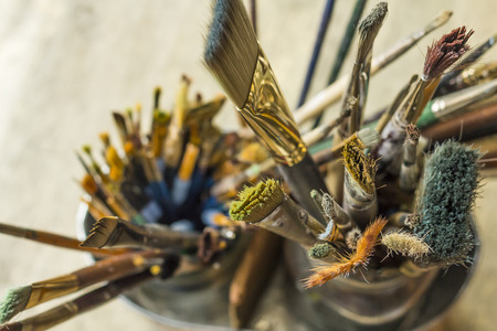 Container kit of assorted and stained old artist paintbrushesの写真素材