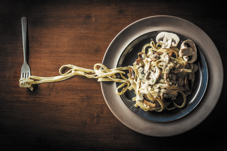 Fancy organic fetuccine pasta with creamy alfredo mushroom sauceの写真素材