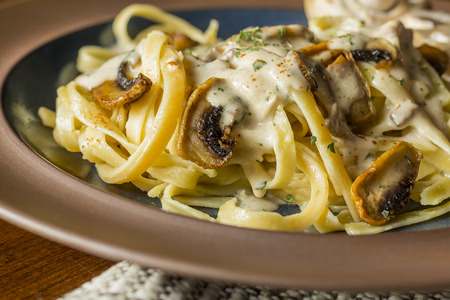 Fancy organic fetuccine pasta with creamy alfredo mushroom sauceの写真素材