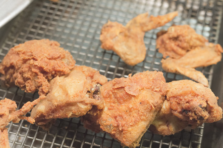 Cripsy fried chicken wings breasts and legs in restaurant pan