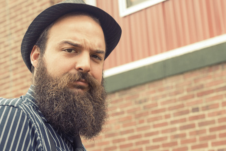 Well dressed bearded man questions the viewer with a confused expression