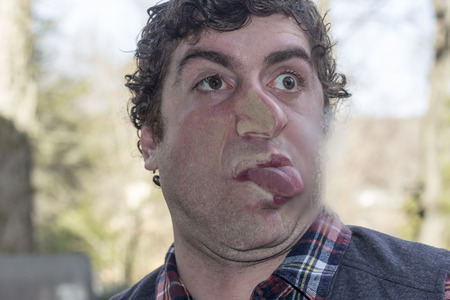Crazy lunatic man smooshes face against glass surfaces