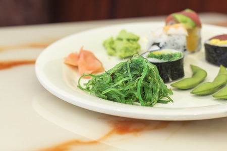 Assorted plate of Japanese sushi demonstrating variety including edamame and seaweed saladの写真素材