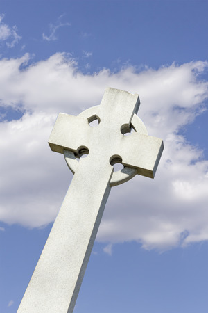 Grave stone cross against a perfect blue skyの写真素材