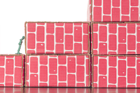 Green army man banging head against a brick wallの写真素材