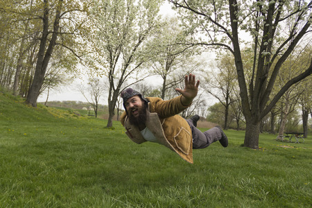 Bearded aviator soars through the air like an airplaneの写真素材