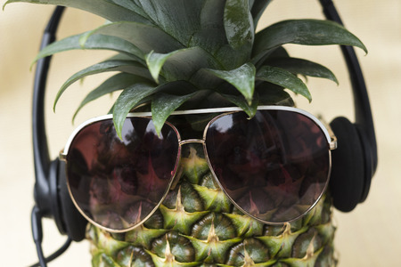 Cool pineapple with sunglasses and headset in summer themed photoの写真素材