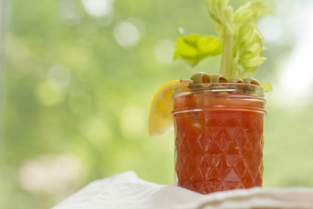 Bloody Mary vodka cocktail made at home sitting on counter by windowの写真素材