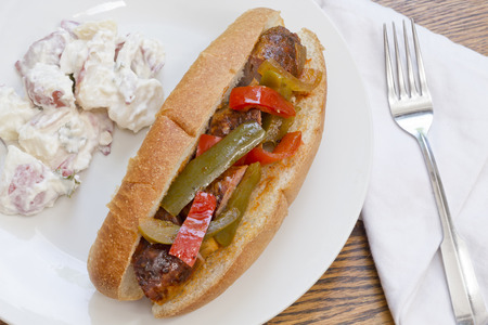 Fried sausage onions and red and green bell peppers on sandwich bunの写真素材