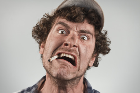 Angry redneck yells and shouts while smoking a cigarette