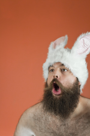 Amazed bearded fat man wears silly bunny earsの写真素材