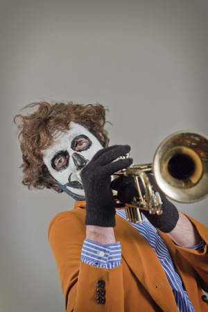 Professional trumpet player with face painted as human skullの写真素材