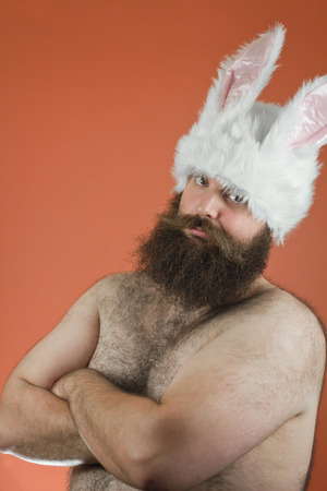 Confident bearded fat man wears silly bunny earsの写真素材