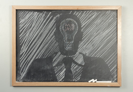 Silhouette of businessmanand lightbulbs drawn onto dirty school chalkboardの写真素材