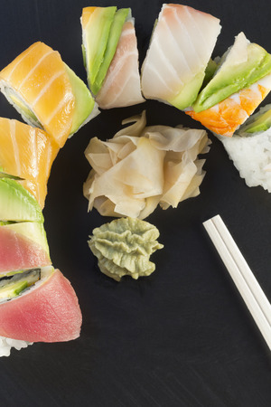 Rainbow sushi roll sliced with wasabi and fresh gingerの写真素材