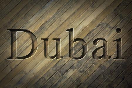 Engraving spelling the city Dubai on textured old surface