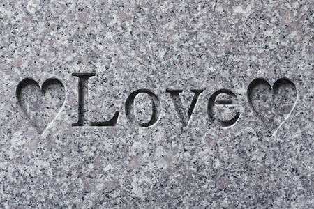 Engraving spelling the word Love on textured old surfaceの写真素材