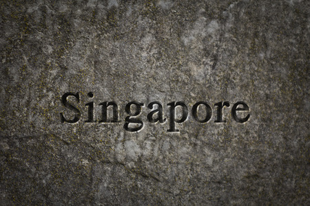 Engraving spelling the city Singapore on textured old surfaceの写真素材