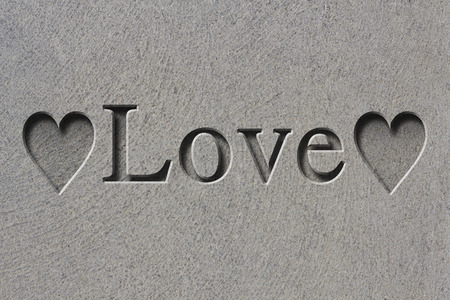 Engraving spelling the word Love on textured old surfaceの写真素材