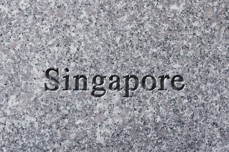 Engraving spelling the city Singapore on textured old surfaceの写真素材