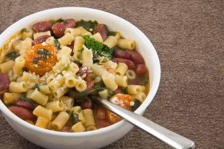 Hearty minestrone soup in white bowl for winter eatingの写真素材