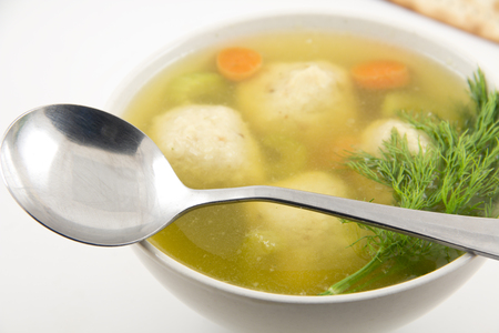 Delicious Matzoh ball soup with crackers wine and dillの写真素材