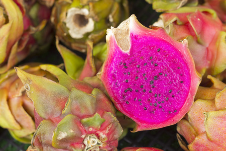 Juicy exotic sliced pink dragonfruit on display at local farmers marketの写真素材