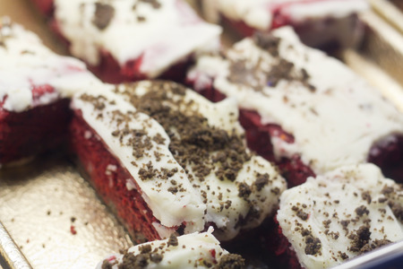 Sliced fresh red velvet cake squares on display at local bakeryの写真素材