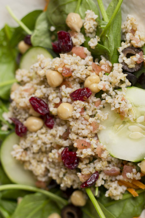 Fresh and healthy quinoa salad on bed of spinach with dried cranberriesの写真素材