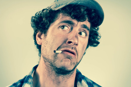 Scared redneck cowardly smoke a cigarette and searches for dangerの写真素材