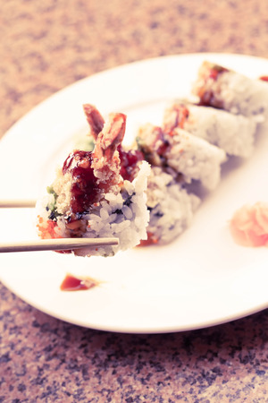 Shrimp tempura avocado sushi roll with sweet sushi sauceの写真素材