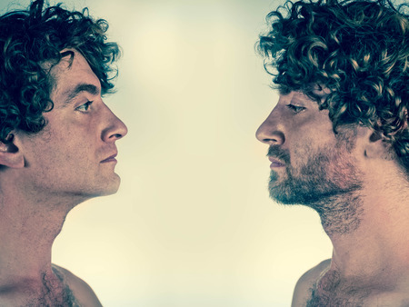 Half shaved man looking at himself with and without a beardの写真素材