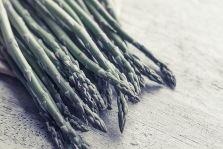 Fresh organic asparagus straight from the farmer's market on distressed table topの写真素材