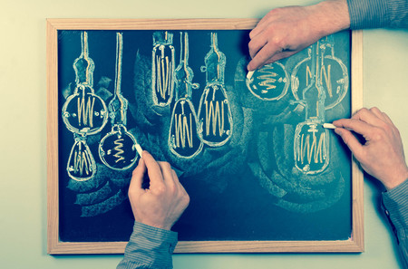 Variety of antique edison style lightbulbs drawn on chalkboardの写真素材
