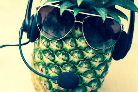 Cool pineapple with sunglasses and headset in summer themed photoの写真素材