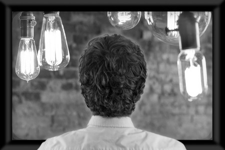 Back of man's head as he's watching flat screen televisionの写真素材