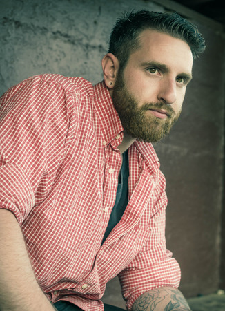 Portrait of bearded young man with gauged ears and stylish hairの写真素材