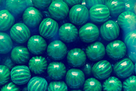 Close up of green candy gum balls in candy machineの写真素材