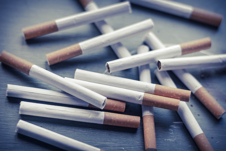 Cigarette arrangement on green grungy wood surface, tobacco industry backgroundの写真素材