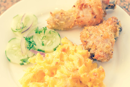 Country fried chicken with home made macaroni and cheese with cucumbersの写真素材