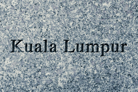 Engraving spelling the city Kuala Lumpur on textured old surfaceの写真素材