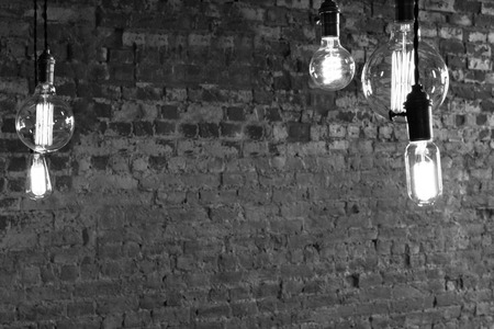 Decorative antique edison style light bulbs against brick wall background