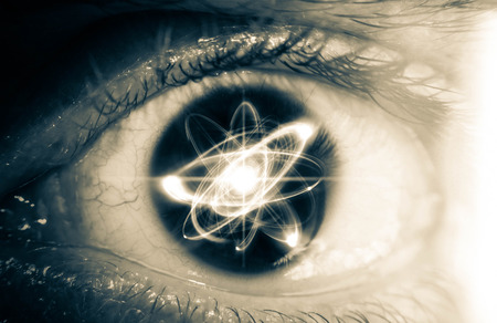 Atomic particle reflection in the pupil of an eye for physics backgroundの写真素材