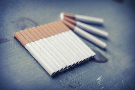 Cigarette arrangement on green grungy wood surface, tobacco industry backgroundの写真素材