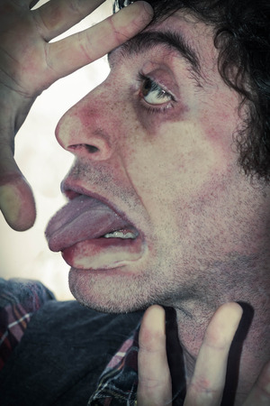 Crazy lunatic man smooshes face against glass surfacesの写真素材